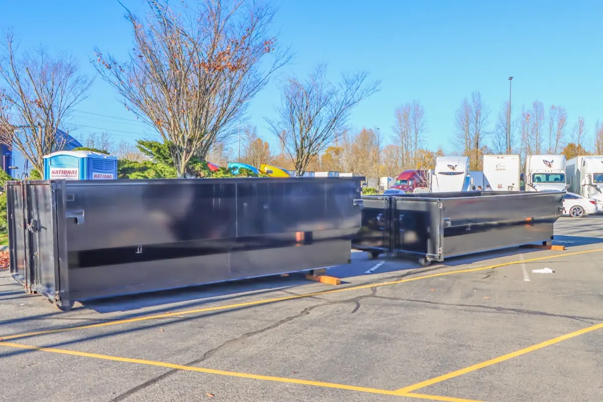 Professional dumpster rental service with roll-off container on residential driveway in Woodside